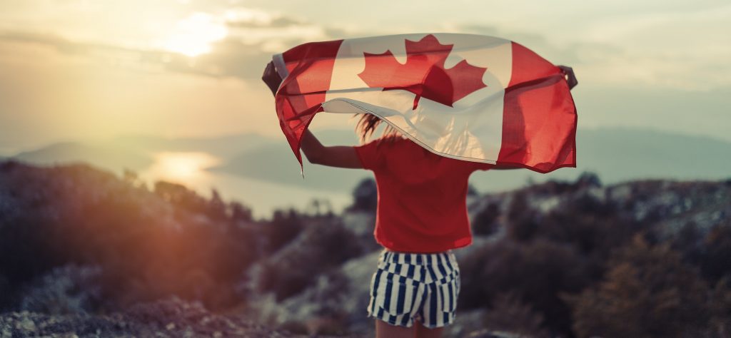 Persona con bandera de Canada en un paisaje