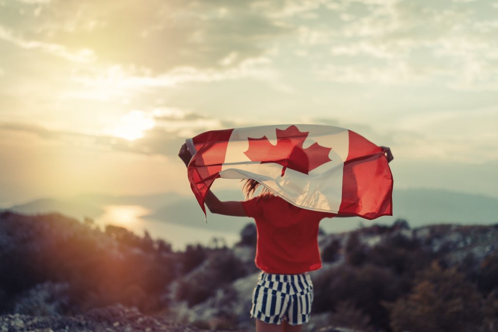 Mujer con bandera de Canada en un paisaje